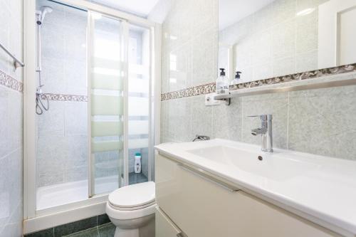La salle de bains blanche est pourvue de toilettes et d'un lavabo. dans l'établissement Zona Garbí, à Valence