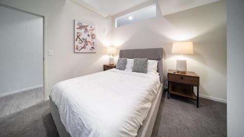 a bedroom with a large white bed and two lamps at Landing Modern Apartment with Amazing Amenities (ID4770X14) in Cleveland
