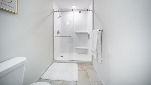 een witte badkamer met een douche en een toilet bij Landing Modern Apartment with Amazing Amenities (ID4770X14) in Cleveland