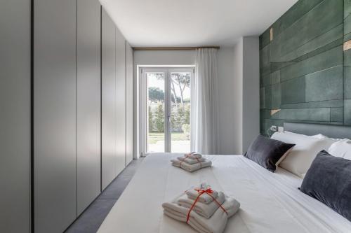 um quarto com uma grande cama branca com duas toalhas em The Tropical Corner by Rentbeat em Roma