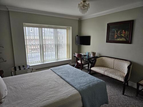 a bedroom with a bed and a chair and a window at Lowell Inn in Stillwater