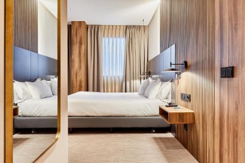Habitación de hotel con cama y espejo en Silken Ciudad Gijón en Gijón