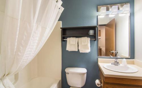 un bagno con un water, un lavandino e uno specchio di WoodSpring Suites Port Orange - Daytona Beach a Port Orange