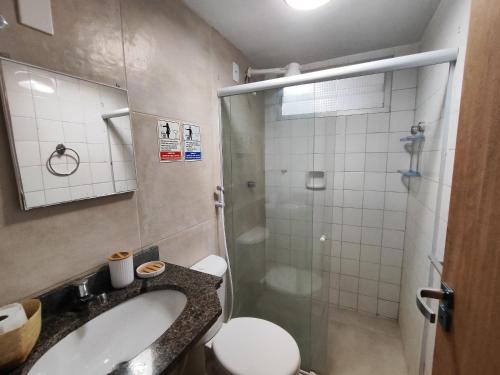 a bathroom with a shower and a sink and a toilet at Temporada Beira-Mar Maceió in Maceió