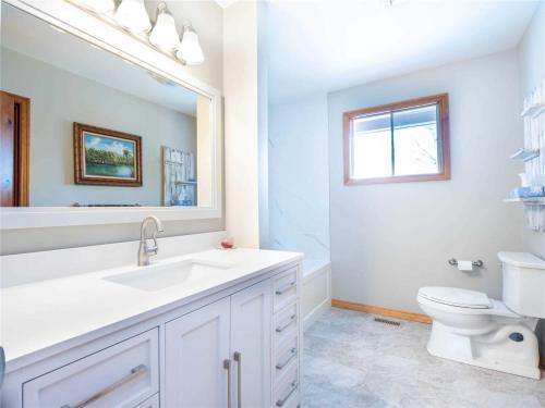 a white bathroom with a sink and a toilet at Countryside Farm Estate - Bnb in Orillia