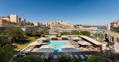 an aerial view of a resort with a pool and umbrellas at Radisson Blu Hotel Marseille Vieux Port in Marseille