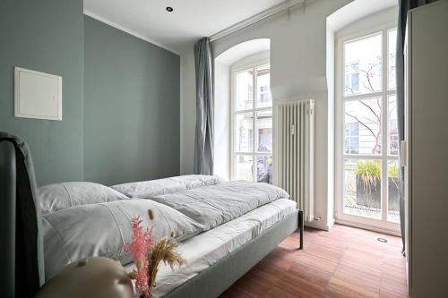a bedroom with a bed and a large window at Central Apartment - Linienstraße in Berlin