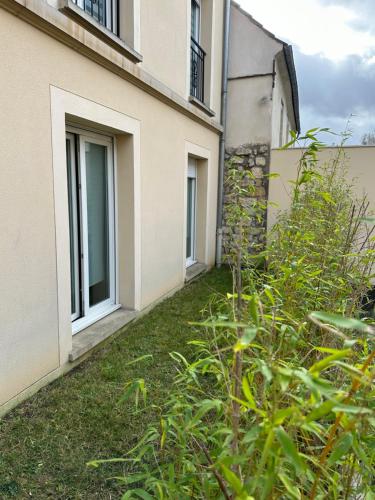 a garden in front of a building at Accueillant et pratique, proche de Chantilly et du parc Asterix in Lamorlaye