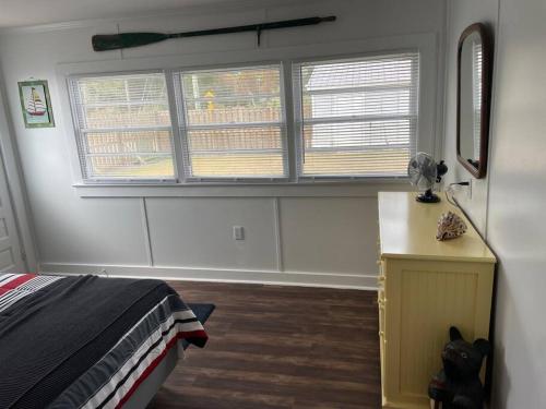 1 dormitorio con cama, ventana y escritorio en The Cottage, en Wilmington