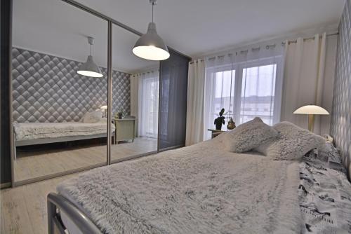 a bedroom with a large mirror and a bed at Apartamenty Bryza - Debina in Świnoujście