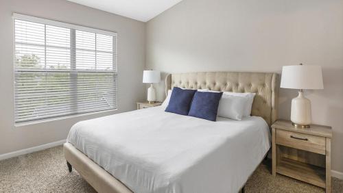 a white bedroom with a large bed with blue pillows at Landing Modern Apartment with Amazing Amenities (ID7649X87) in Dublin