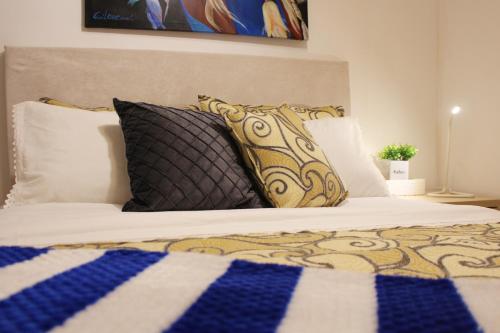a bed with black and white pillows at Apartamento Centro de Pontevedra in Pontevedra