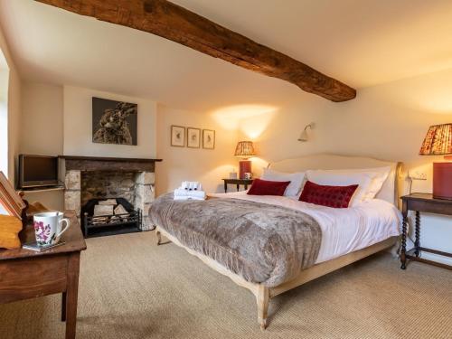 a bedroom with a large bed and a fireplace at 3 Bed in Bath SKN21 in Wellow