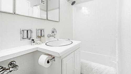 a white bathroom with a sink and a tub at Landing Modern Apartment with Amazing Amenities (ID1222X746) in Chicago
