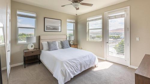 a bedroom with a bed with a ceiling fan and windows at Landing Modern Apartment with Amazing Amenities (ID7328X47) in Sparks