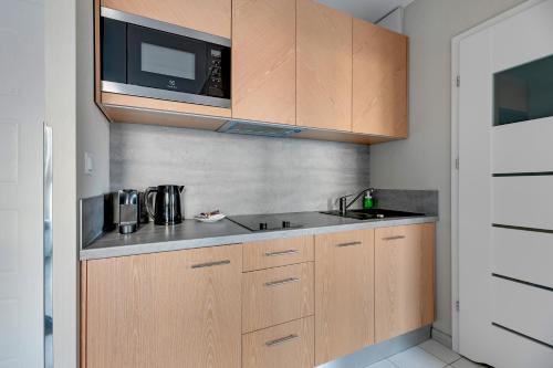 a kitchen with a sink and a microwave at Dom & House - Apartments Angielska Grobla - Self Check-in in Gdańsk