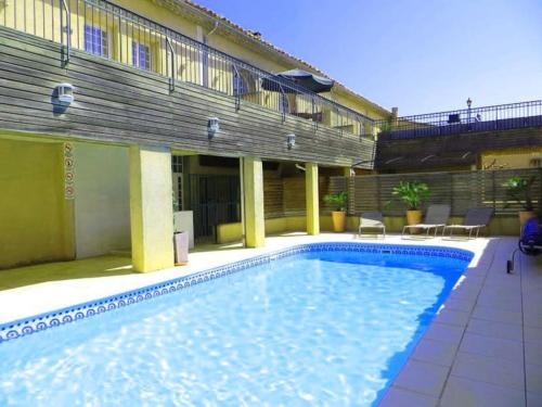 une grande piscine devant un immeuble dans l'établissement Château Winery la Batisse le minervois, à Laredorte