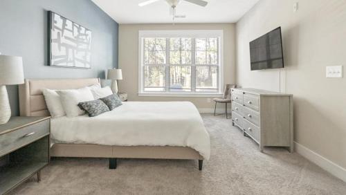 1 dormitorio con 1 cama, vestidor y ventana en Landing Modern Apartment with Amazing Amenities (ID7828), en Raleigh
