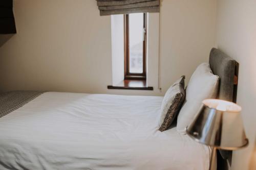 a bedroom with a bed with pillows and a window at Pattys Barn Holiday Cottages, Cabins and Venue Hire in Cockerham