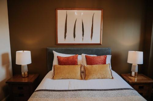 a bedroom with a bed with pillows and two lamps at Pattys Barn Holiday Cottages, Cabins and Venue Hire in Cockerham