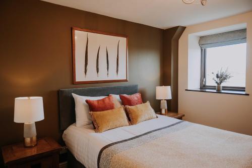 a bedroom with a bed and two lamps and a window at Pattys Farm Barn in Cockerham