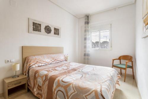 a bedroom with a bed and a chair and a window at Zona Garbí - B in Valencia