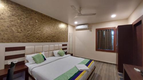 a bedroom with a large bed and a window at Goroomgo New Paradise Industrial Estate Bhubaneswar in Bhubaneshwar