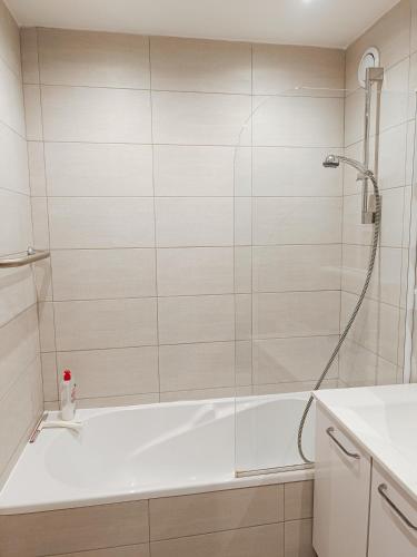 a bathroom with a shower and a white tub at logement climatisé à Juan les Pins dans résidence avec piscine in Juan-les-Pins