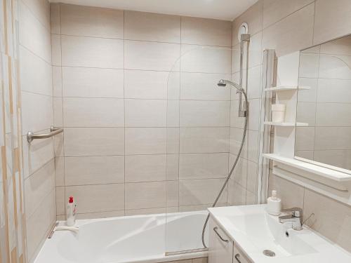 ein weißes Badezimmer mit einer Badewanne und einem Waschbecken in der Unterkunft logement climatisé à Juan les Pins dans résidence avec piscine in Juan-les-Pins