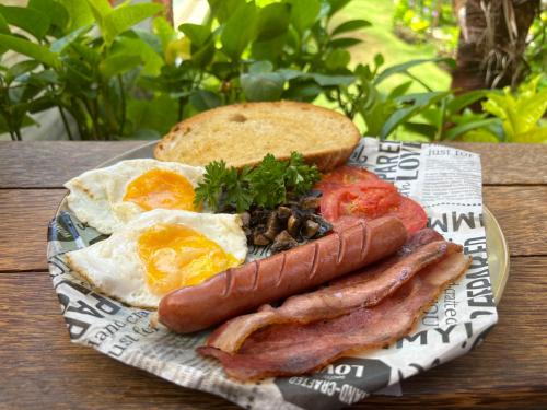 een bord ontbijtproducten met eieren, spek en toast bij Villa Dea in Nusa Dua