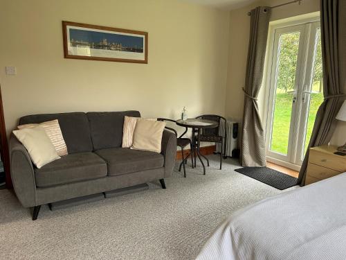 a living room with a couch and a table at Whidlecombe Farm in Priston