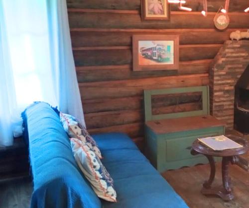 a living room with a blue couch and a table at Casa de toras in Campo Alegre