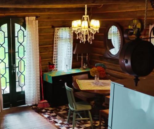 a dining room with a table and a chandelier at Chalé de Toras in Campo Alegre