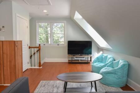 a living room with blue chairs and a tv at Contemporary Gem with Private Pool in Barnstable