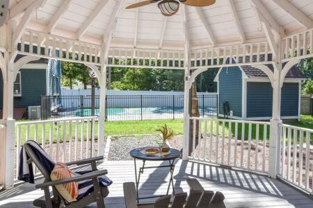a white gazebo with a table and chairs on a porch at Contemporary Gem with Private Pool in Barnstable