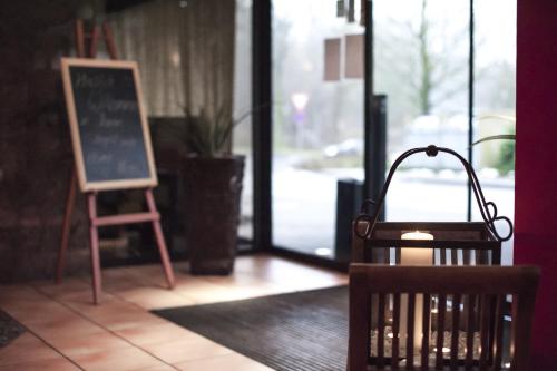 a chalk board and a chair in front of a door at Stargaze Home Hotel in Haan