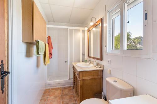 uma casa de banho com um lavatório, um WC e uma janela. em Garruchal 