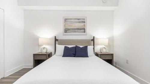 een witte slaapkamer met een groot bed met 2 nachtkastjes bij Landing Modern Apartment with Amazing Amenities (ID7588X22) in Fort Myers