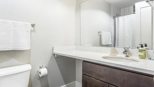 ein weißes Bad mit einem Waschbecken und einem WC in der Unterkunft Landing Modern Apartment with Amazing Amenities (ID1239X428) in Richmond