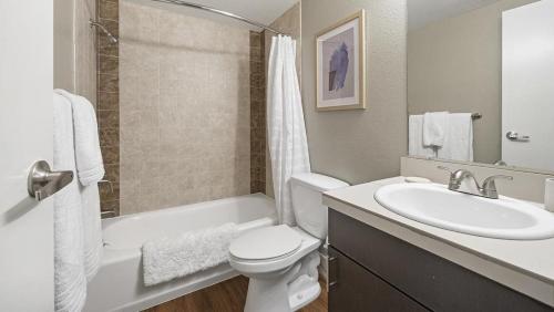 Landing Modern Apartment with Amazing Amenities (ID9230X68) في لونغمونت: حمام مع حوض ومرحاض وحوض استحمام