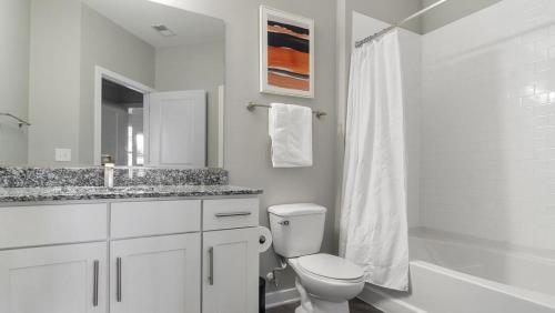 a white bathroom with a toilet and a sink at Landing Modern Apartment with Amazing Amenities (ID1358X777) in Chapel Hill