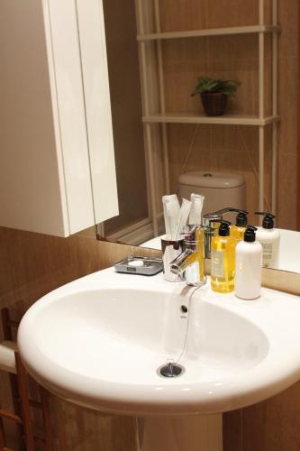 a white sink in a bathroom with a mirror at Apartamento Centro de Pontevedra in Pontevedra