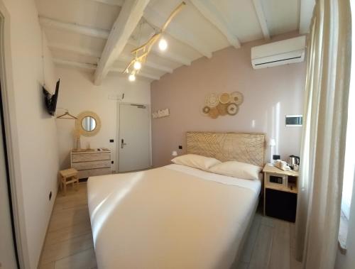 una camera con un grande letto bianco e una scrivania di La Corte Country Rooms a Modena
