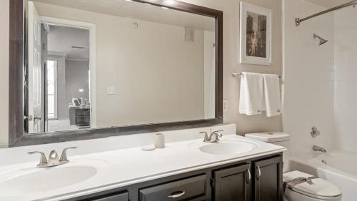 a bathroom with a sink and a mirror and a toilet at Landing Modern Apartment with Amazing Amenities (ID8229X54) in Plano