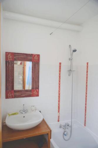 une salle de bain avec un lavabo, une baignoire et un miroir dans l'établissement Villa Eden maison de pêcheur traditionnelle avec jardin, à Cayeux-sur-Mer