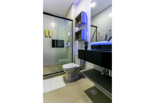 een badkamer met een toilet, een wastafel en een spiegel bij Studio em condomínio c/ piscina 700m praia STI210 in Florianópolis