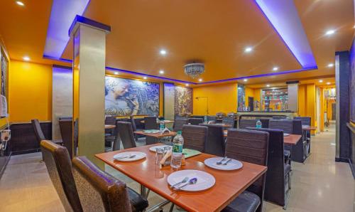 un restaurante con mesas y sillas de madera y paredes amarillas en HOTEL GREEN VIEW PALACE, en Ghaziabad