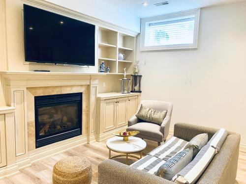 ein Wohnzimmer mit einem Kamin und einem TV in der Unterkunft Stylish Private Suite with 2 Bedrooms in Midtown in Toronto