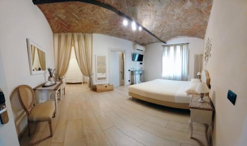 a large bedroom with a bed and a stone wall at La Corte Country Rooms in Modena