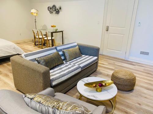 sala de estar con sofá y mesa en Stylish Private Suite with 2 Bedrooms in Midtown en Toronto